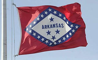 NWA Media/FLIP PUTTHOFF 
CHRISTMAS BREEZE
The Arkansas state flag is whipped by the wind on Christmas Day    Dec. 25 2014  at Rogers Heritage High School in Rogers. The flag's diamond shape symbolizes that Arkansas is the only diamond-producing state, says the online "Encyclopedia of Arkansas." The 25 outside stars symbolize that Arkansas was the 25th state to enter the Union. The original flag design created in 1913 did not feature the state's name. It is now part of the current flag design approved by  the General Assembly in 1924.